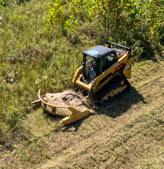 Skid steer clearing brush